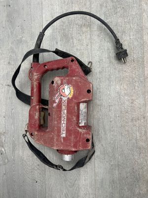 a red tool that is laying on a wooden floor