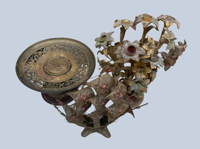 a gold vase with flowers and a plate on it