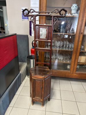 une armoire en bois avec une porte vitrée, dans un coin de la pièce