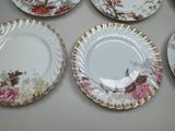 several plates with floral designs are arranged on a table
