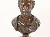 a bronze bust of a man with a beard and a scarf around his neck