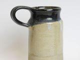 a black and white pitcher sitting on a white surface