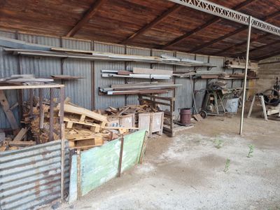 Plusieurs morceaux de bois sont empilés dans un abri