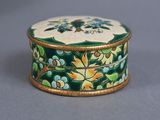 a green and gold box with flowers and leaves on it