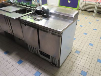 a kitchen with two sinks and a refrigerator in it