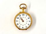 une montre de poche en or avec un cadran blanc sur une surface blanche