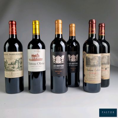 several bottles of wine are lined up on a white surface