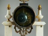 a clock that is sitting on top of a marble stand