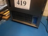 un ordinateur portable posé sur une table bleue, avec une étiquette de prix dessus