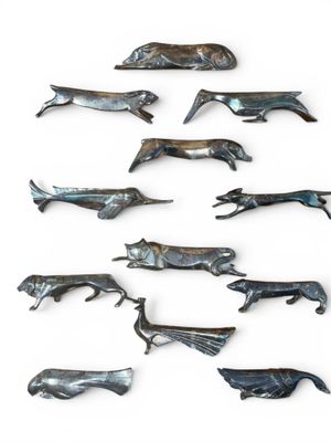 a lot of metal animals that are on a white surface