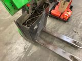 a fork lifter with a green container on it