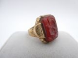 a close up of a gold ring with a red stone in it