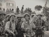 photo en noir et blanc d'un groupe de soldats debout devant un bâtiment