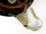 a brown helmet with a tan strap on it