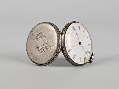 une montre de poche ancienne avec un boîtier en argent et une chaîne en argent