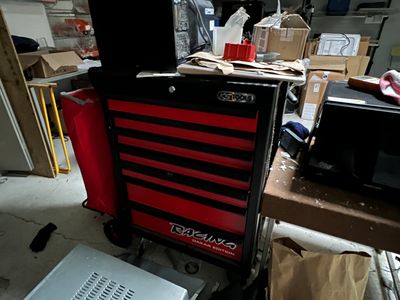une armoire à outils rouge et noire posée dans un garage