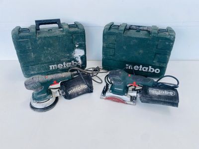 two tools are sitting on a white surface with a green case