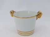 a white vase with gold handles on a white surface