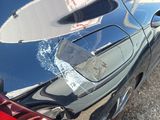 a black car with a broken rear bumper and a broken tail light