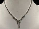a close up of a necklace and earrings on a mannequin