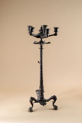 an image of a tall black candle holder on a stand