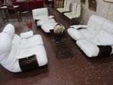 de nombreux canapés et fauteuils blancs dans une pièce