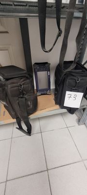 un sac et un téléphone portable posés sur une étagère dans une pièce