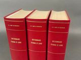 trois livres rouges superposés sur une table