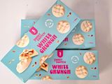 three boxes of white chocolate chip cookies sitting on top of each other