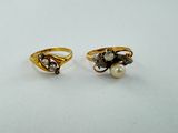 two gold rings with pearls and diamonds on them on a white surface
