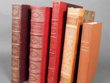 several books are lined up in a row on a gray surface