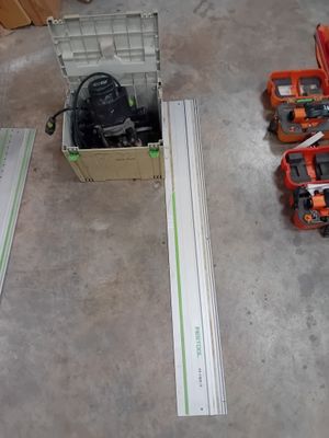 une boîte à outils posée par terre à côté de deux perceuses