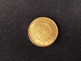 a close up of a gold coin on a black surface