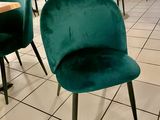 Des tables et des chaises sont alignées dans une pièce au sol carrelé.