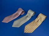 three different colored ties on a blue surface with a blue background
