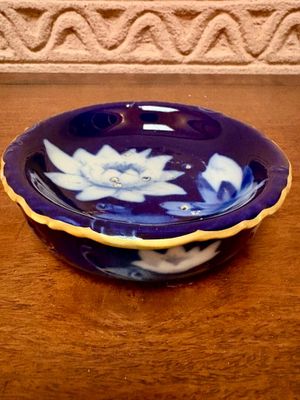 un bol bleu orné de fleurs blanches, posé sur une table
