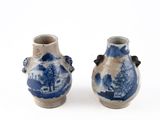 pair of blue and white vases sitting on top of a white surface