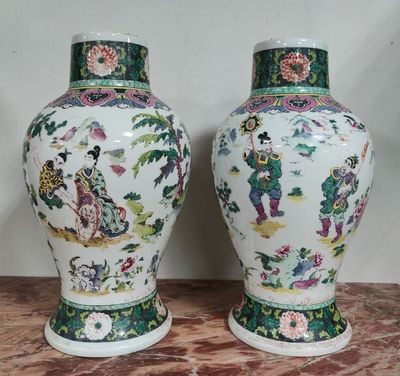 une paire de vases chinois posés sur une table en marbre, avec un mur en arrière-plan
