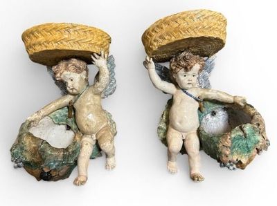 deux figurines d'anges portant des paniers sur la tête