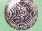a silver coin with an image of a man and a woman on it