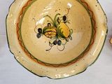 a bowl with a bee on it next to a bowl with a bee on it