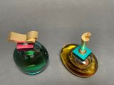 two different colored glass objects sitting on a table
