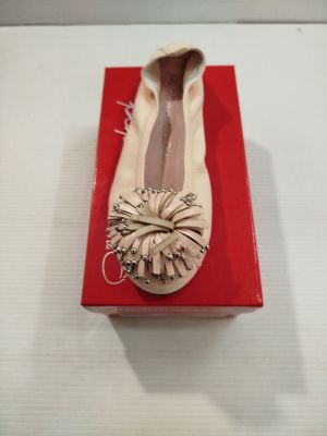 quelqu'un porte une paire de chaussures qui se trouvent sur une boîte rouge