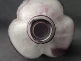 a white and purple bead with a hole in it