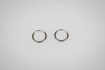 a pair of silver hoop earrings on a white background