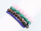un gros plan sur une pile de trois bracelets composés de perles de différentes couleurs