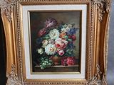 une peinture à l'huile représentant des fleurs, dans un cadre doré, posée sur un chevalet