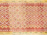 a red and yellow rug on a wooden floor