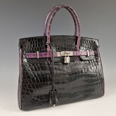 un gros plan sur un sac à main en peau d'alligator noir et violet