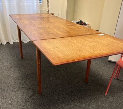 a wooden table with a red chair in front of it